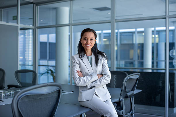 happy businesswoman sitting arms crossed in office - fato de senhora imagens e fotografias de stock