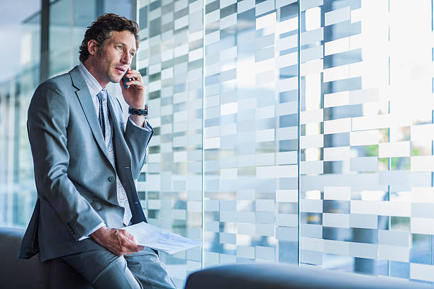 businessman using mobile phone in office - reflection businessman business telephone photos et images de collection