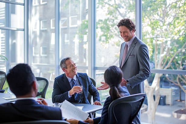 happy businesspeople talking in board room - board room group of people business person clothing стоковые фото и изображения