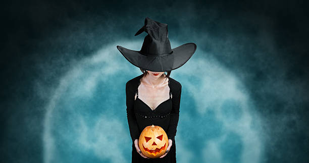 istock Witch holds Halloween pumpkin at midnight 530285565