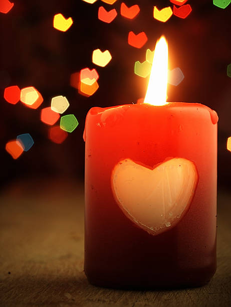 istock Red candle on the table and shiny hearts in background. 530300675
