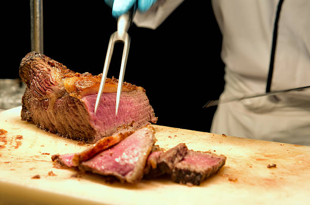 Carving the prime rib steak Chef's hands cutting prime rib steak on board brisket photos stock pictures, royalty-free photos & images