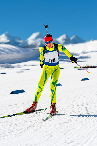 Front view of young female biathlon competitor leaving the shooting range
