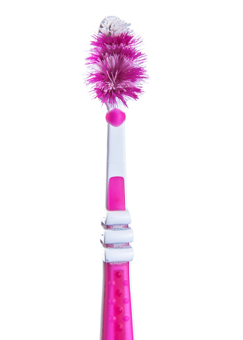 Close-up of old pink toothbrush on a white background.