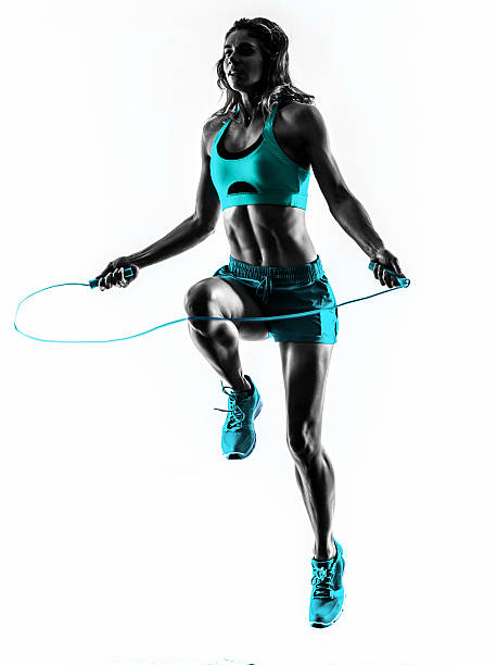 Donna fitness esercizi silhouette di saltare la corda - foto stock