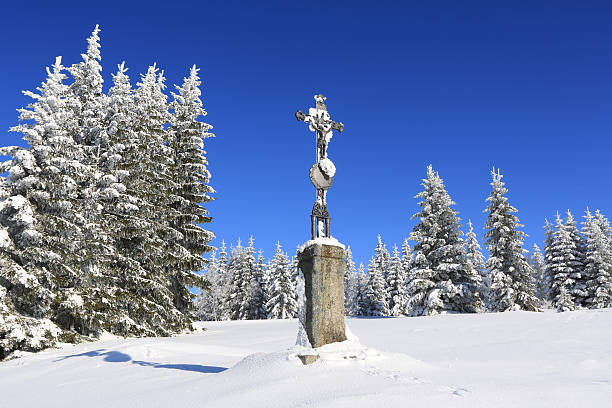 Winter landscape with stone cross and snow wrapped trees in Sumava, Czech republic