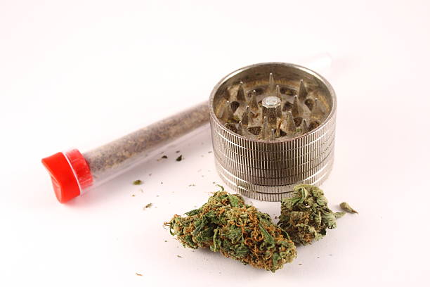 istock Cannabis with joints in metallic grinder on white background 530307181
