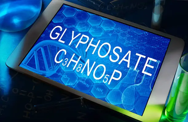 the chemical formula of glyphosate on a tablet with test tubes  