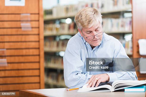 Mature Man Reading In The Library Stock Photo - Download Image Now - 50-59 Years, 55-59 Years, Adult