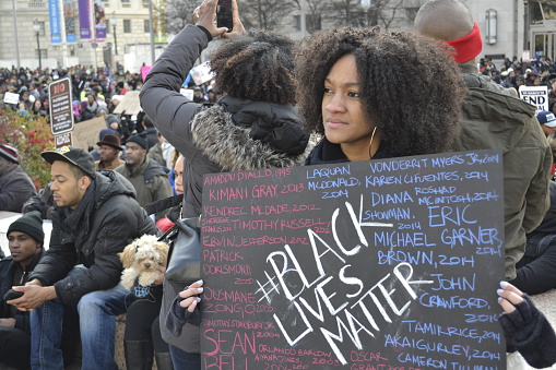 Washington D.C., USA - December 13, 2014: A young woman holds a sign at the protest march in Washington DC to bring attention to the recent shooting deaths of several unarmed black men by police.