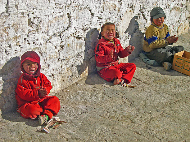 Lhasa, Tibet , China - November 12, 2004: young pilgrims  praying at the Drepung temple. The temple houses about 700 monks and attracts over 1 million pilgrims each year. 