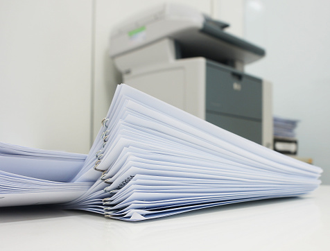 The document has been printed, be set and arranged as pile in front of the copier at office.