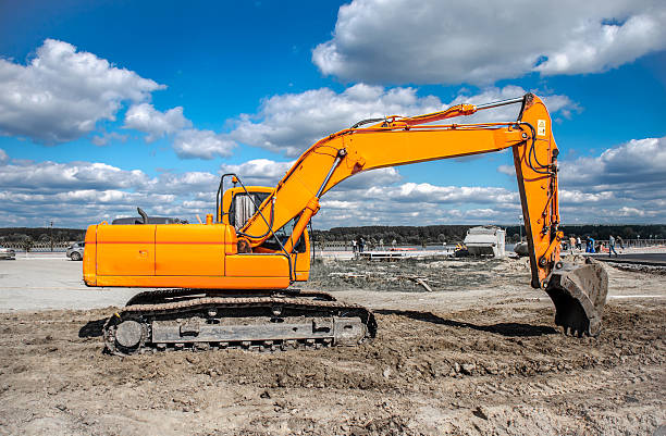 jaune nouveau excavator de travail au rez-de-chaussée - construction equipment earth mover hydraulic platform cylinder photos et images de collection