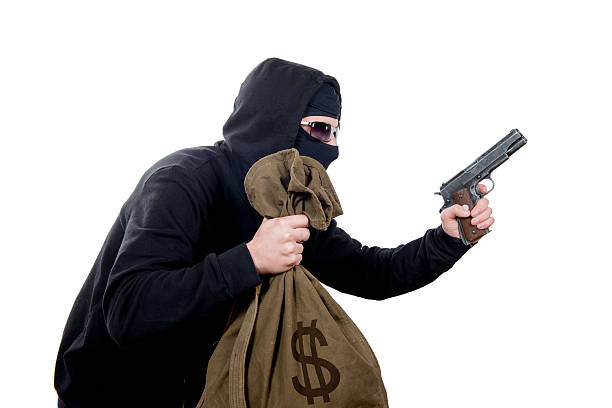 ladrón de capucha con un arma y una bolsa de dinero - gun currency crime mafia fotografías e imágenes de stock