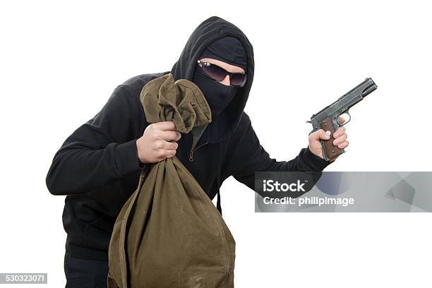 Hooded Robber With A Gun And A Bag Of Money Stock Photo - Download Image Now - Bank - Financial Building, Banking, Handgun