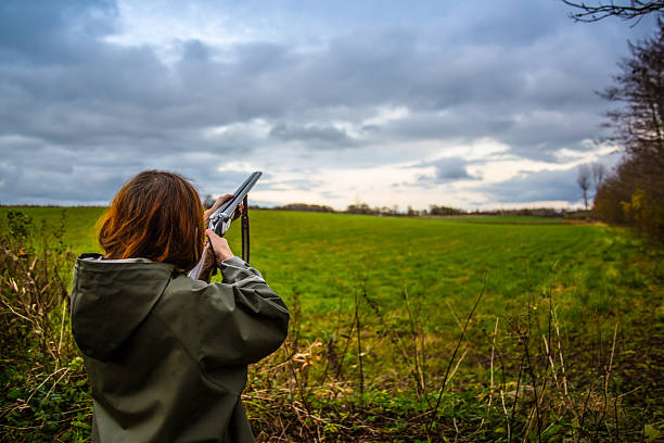 Girl_Shoot_skeet_2 Girl with shotgun skeet shooting on a field in the sunset target shooting photos stock pictures, royalty-free photos & images