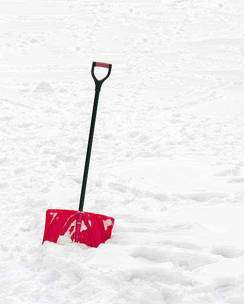 istock Red plastic shovel with black handle stuck in fluffy snow. 530336375