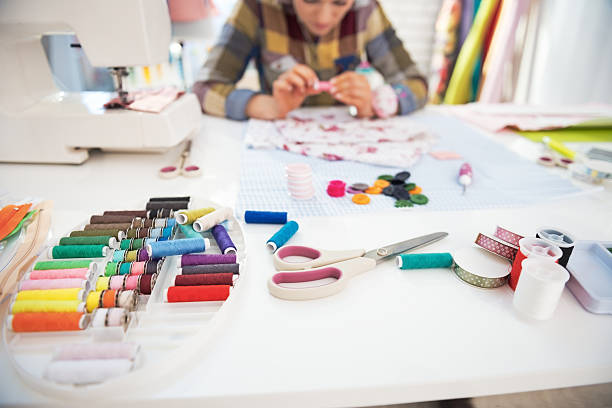 istock closeup on working desk and tailor woman in background 530337549