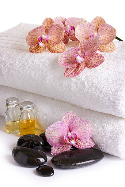 istock pink orchids, cosmetic oil and spa stones 530340733