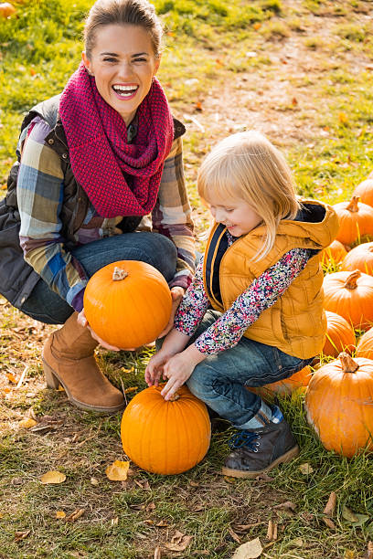 istock smiling mother and child choosing pumpkins 530347935