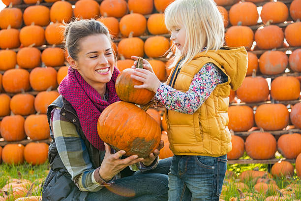 istock mother and child choosing pumpkins 530348075