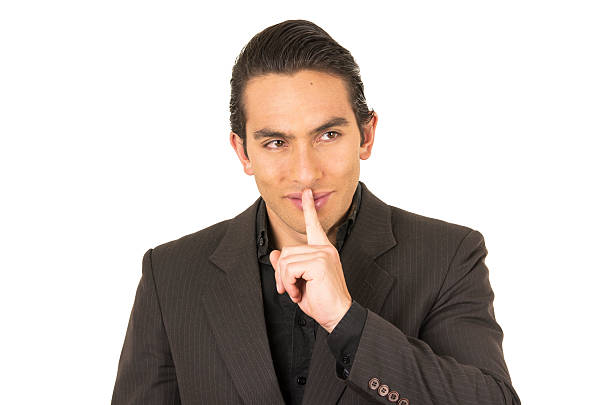 istock handsome young man wearing a suit posing gesturing silence 530362883