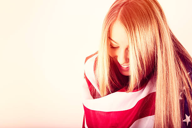 Young woman wrapped in American flag