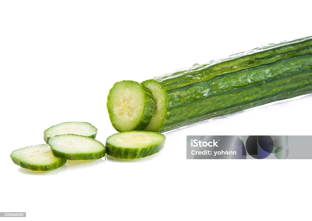 Cucumber A fresh cucumber on a white background. The cucumber has five pieces sliced off, and they are arranged in an appealing way. Blank Stock Photo