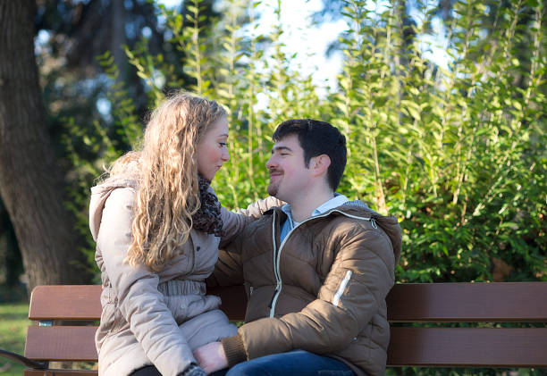 istock Young couple in the park on bench 530366529