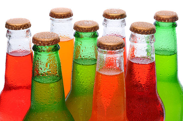 Closeup Asssorted Soda Bottles Closeup of several assorted flavors of soda pop. Orange, lemon lime, and strawberry soda bottles necks only over a white background. soda bottle photos stock pictures, royalty-free photos & images