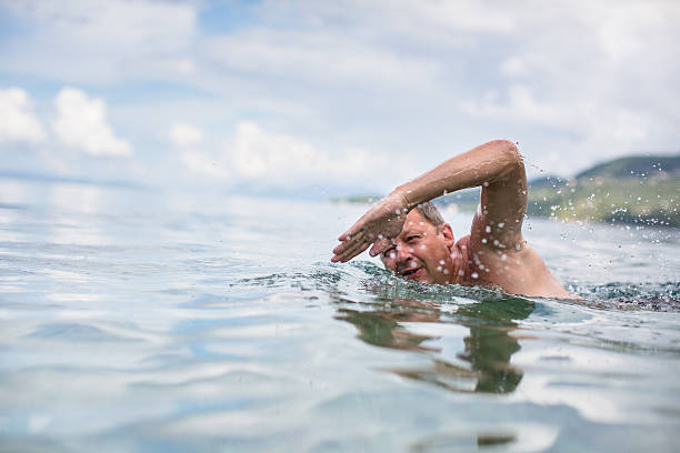 Senior man swimming in the sea stock photo