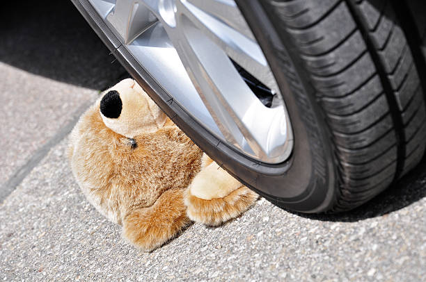 Teddy Teddy under car tires, symbolic car accident with playing children autounfall stock pictures, royalty-free photos & images