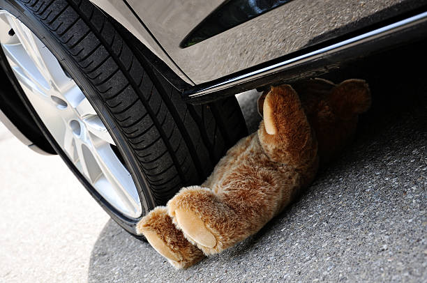 Teddy Teddy under car tires, symbolic car accident with playing children autounfall stock pictures, royalty-free photos & images