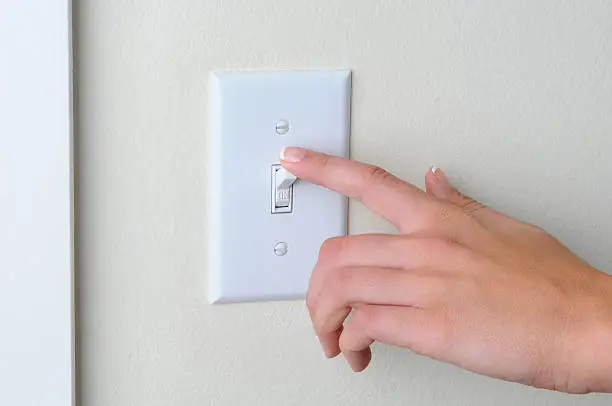 Photo of Woman turning off light switch