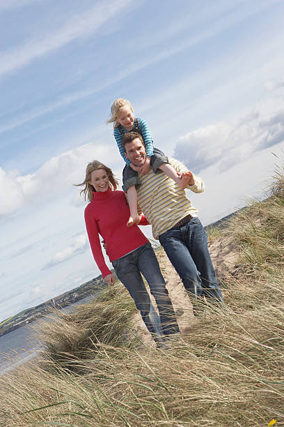 istock Parents With Daughter Walking On Beach 530382947