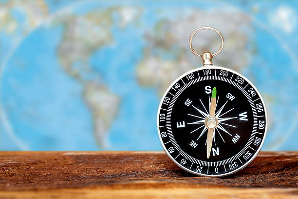 istock Close up compass on wood with blur map background 530390963