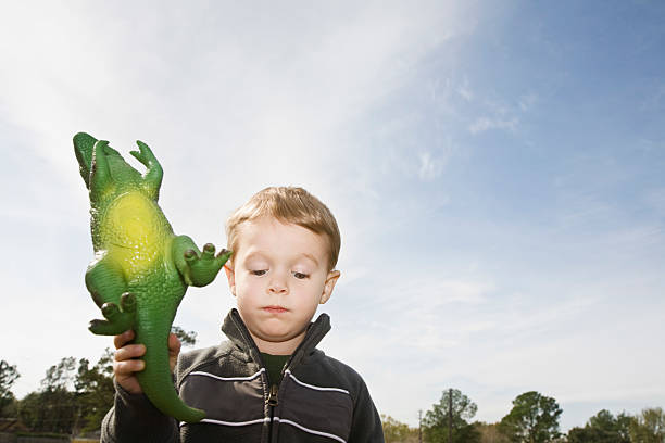 istock Boy Holding Toy Dinosaur 530393339