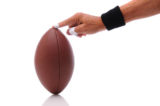 istock Hand holding a football ready for kicking 530393373