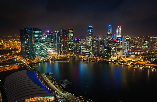 Aerial view over the skyscrapers, hotels, malls and landmarks of Singapore's Central Business District reflecting their twinkling lights in the tranquil waters of Marina Bay. ProPhoto RGB profile for maximum color fidelity and gamut.