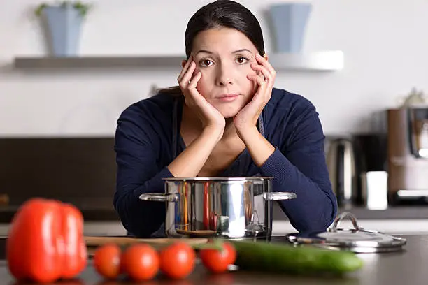 Photo of Unmotivated woman preparing the dinner