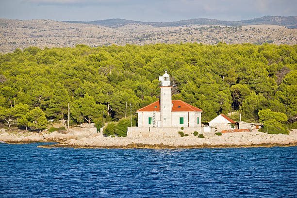 A mystical lighthouse stands proudly against the majestic mountains, symbolizing strength and resilience amidst the captivating coastal landscape of incomparable beauty.