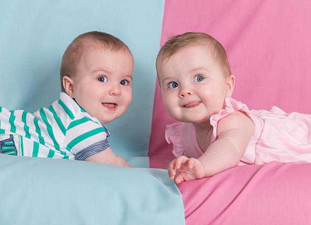 brother and sister brother and sister - twins babies girl and boy on pink and blue background twin stock pictures, royalty-free photos & images