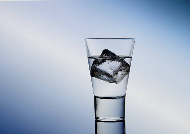 istock Short drink glass with clear liquid and ice cubes 530404965