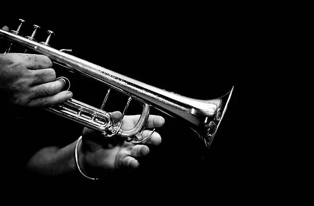 trumpeter playing his trumpet in black and white