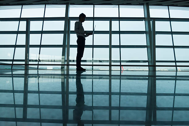 istock Man using laptop at the airport 530410636