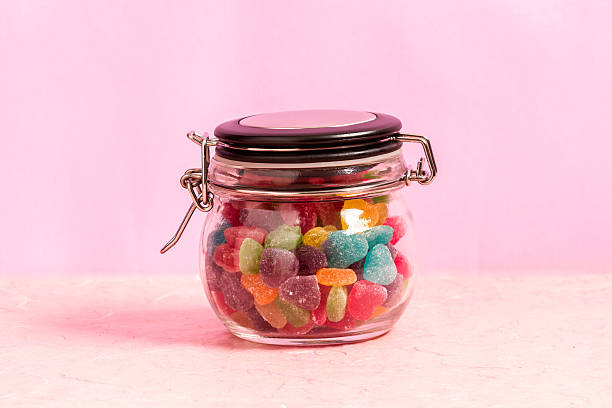 istock Colorful candy in bottle on pink background 530410678
