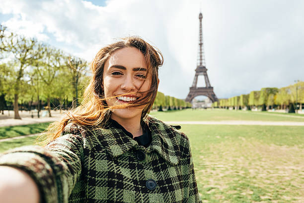 Attractive woman taking selfie in front of the Eiffel tower