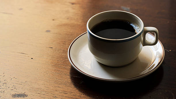 Black coffee on wooden table in dark feel stock photo