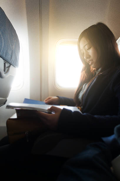 istock Woman reading magazine on airplane 530410984