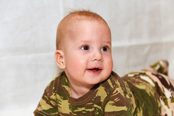 istock The baby in camouflage clothes on a white background 530411110